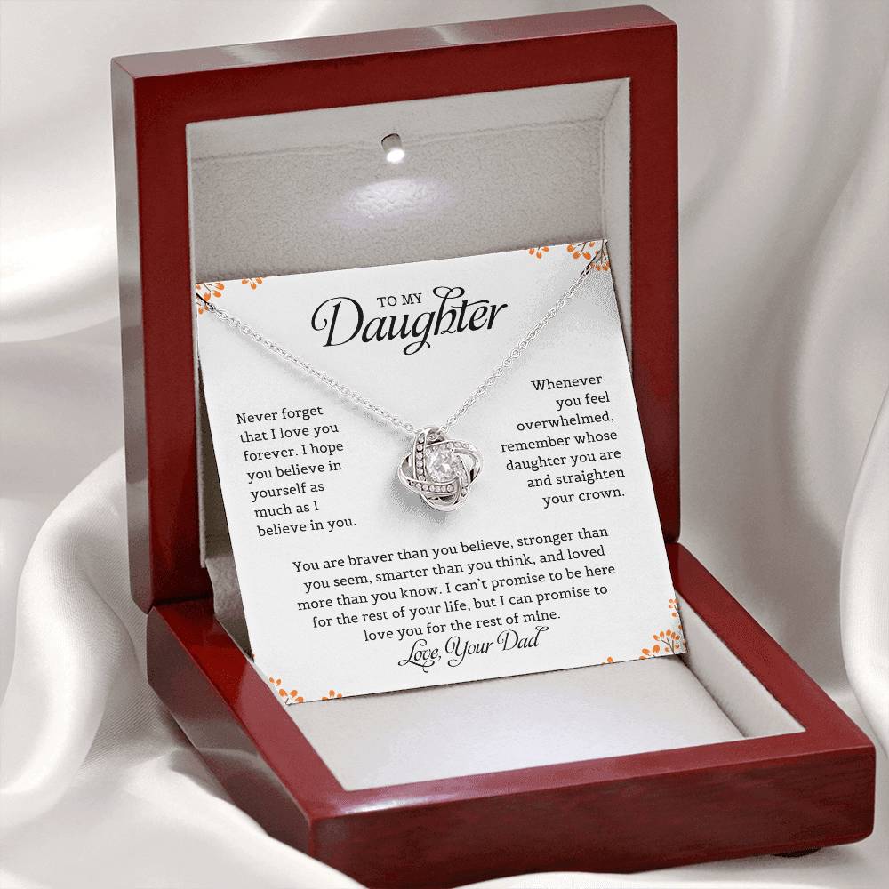 A necklace with a love knot pendant in a mahogany gift box, accompanied by a card with a message to the daughter from dad expressing love and belief in her.