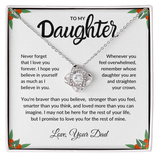 Close up shot of a silver necklace gift in front of a sentimental message card from Dad to Daughter