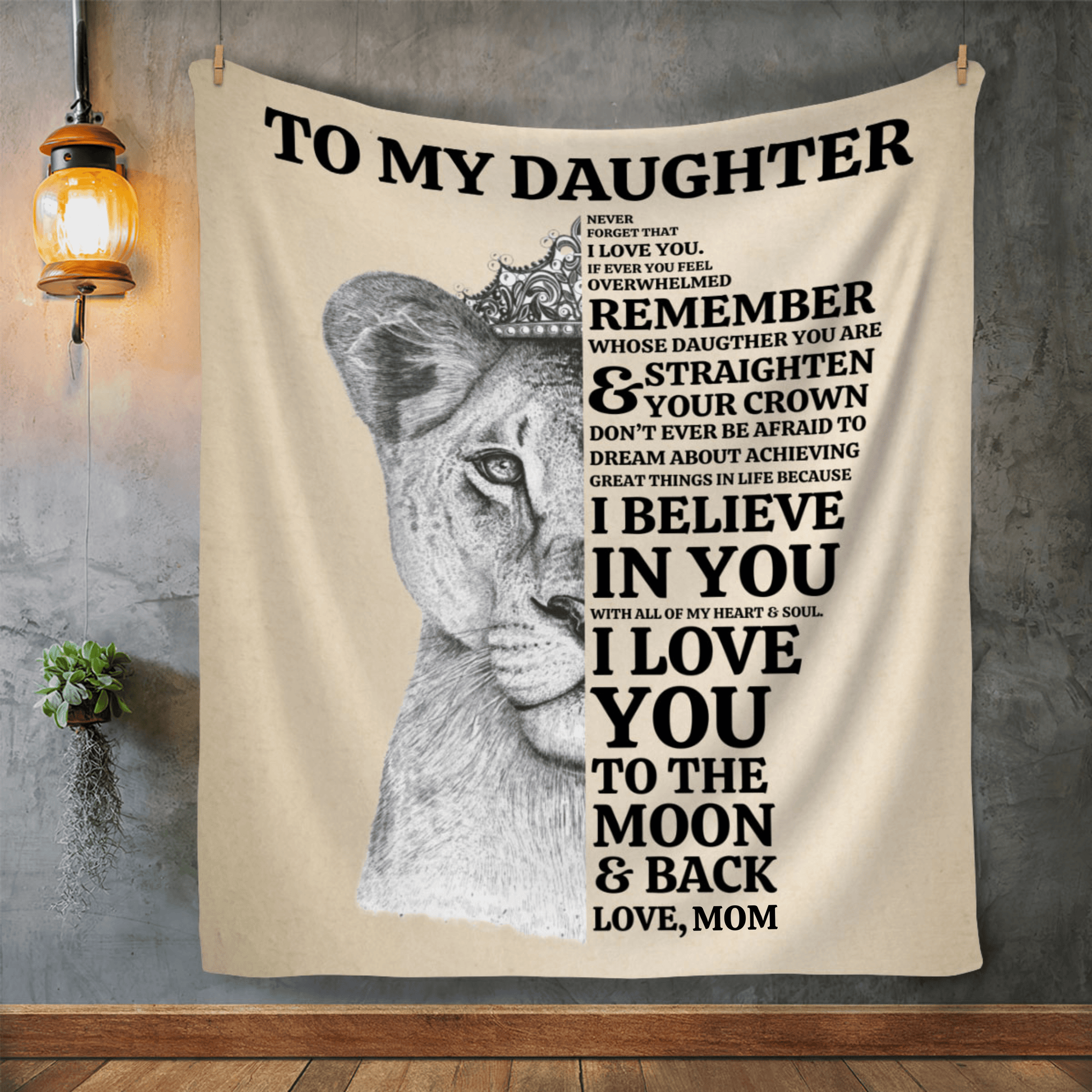 A wall with a tan blanket with a lioness face on it with a message from mom to daughter that says always remember whose daughter you are and straighten your crown. I believe in you and I love you to the moon and back.