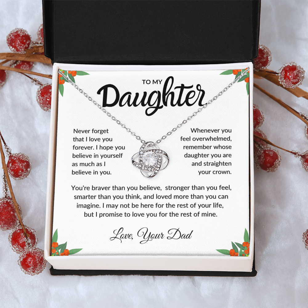 Necklace with a sentimental message card for a daughter, surrounded by decorative elements.