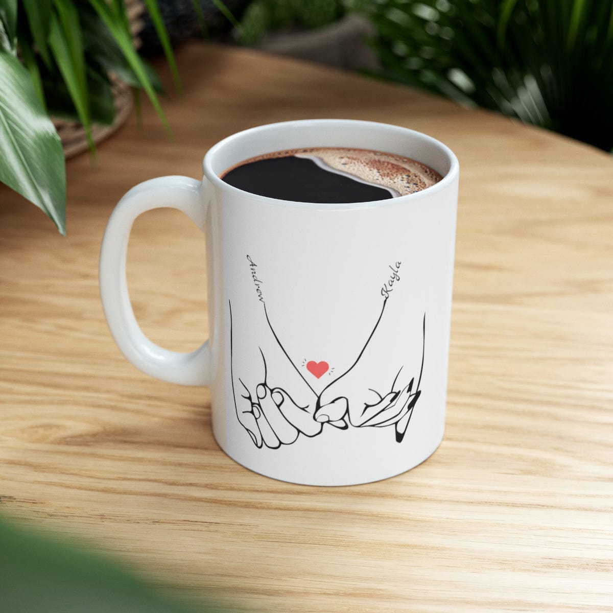 Line art drawing graphic  of hands holding pinkies with the couple's names added to personalize the coffee mug